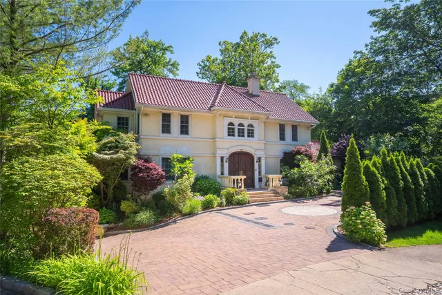 a front view of a house with a garden