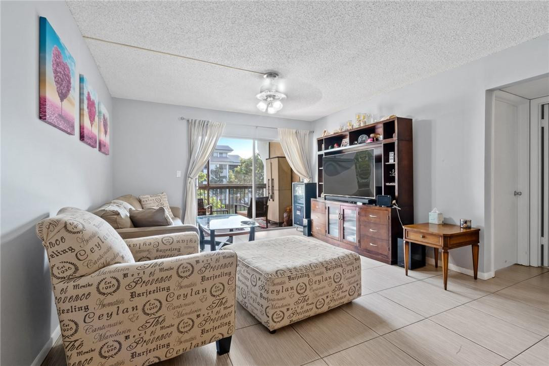 a living room with furniture a flat screen tv and a floor to ceiling window