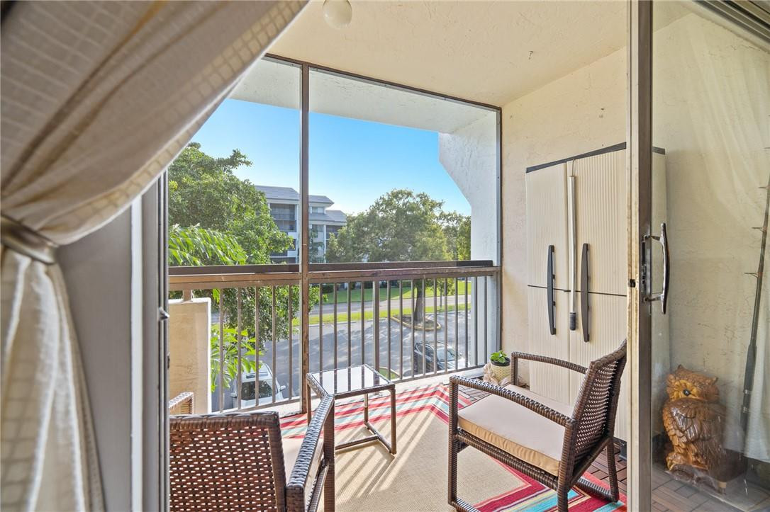 721 North Pine Island Road, Unit 302 Plantation, FL 33324 - Photo 11 of 25 a living room with furniture and a floor to ceiling window
