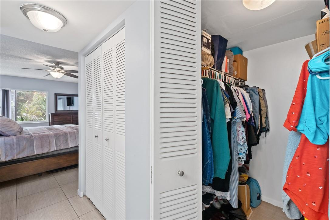 721 North Pine Island Road, Unit 302 Plantation, FL 33324 - Photo 14 of 25 a view of walk in closet with clothes and shoes