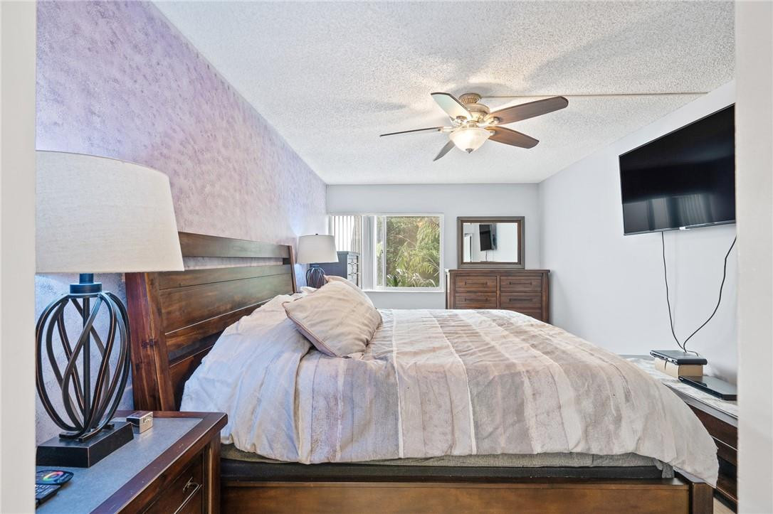 721 North Pine Island Road, Unit 302 Plantation, FL 33324 - Photo 21 of 25 a bedroom with a bed and a flat screen tv