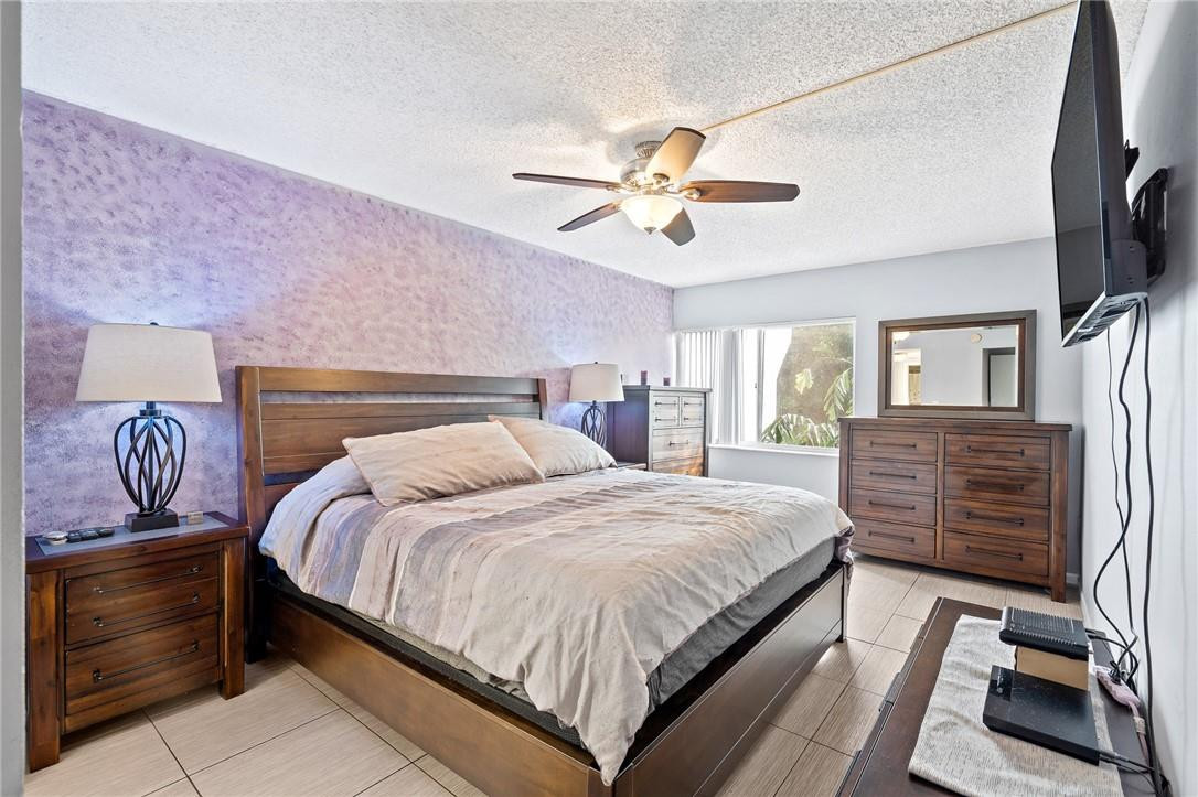 721 North Pine Island Road, Unit 302 Plantation, FL 33324 - Photo 3 of 25 a bedroom with a bed and a chandelier