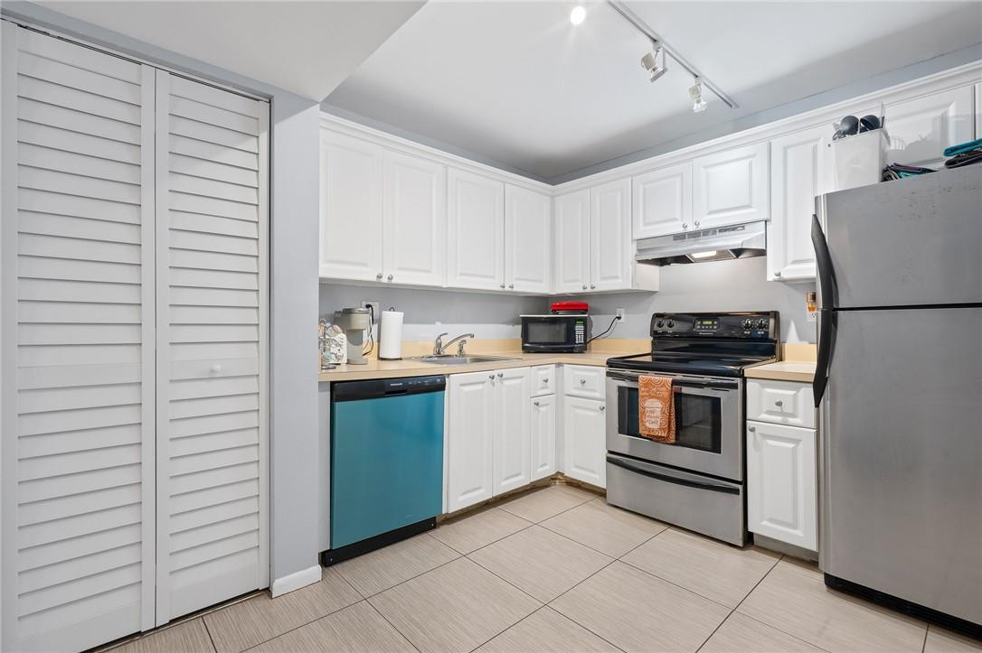 721 North Pine Island Road, Unit 302 Plantation, FL 33324 - Photo 7 of 25 a kitchen with a refrigerator and white cabinets