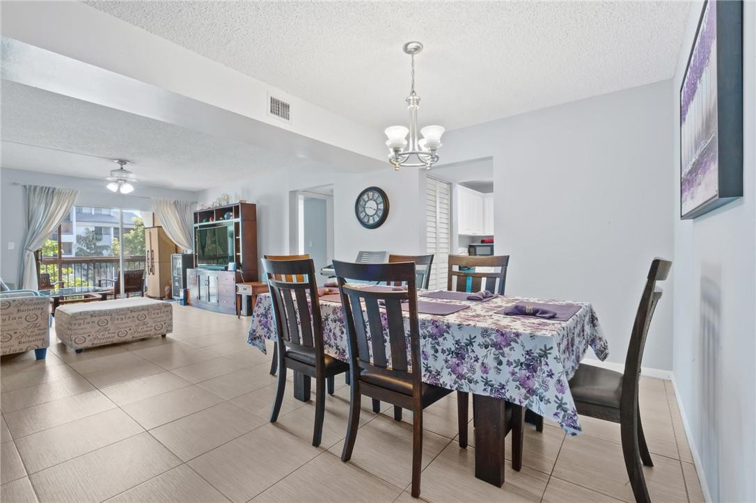 721 North Pine Island Road, Unit 302 Plantation, FL 33324 - Photo 10 of 25 a view of a dining room with furniture and chandelier