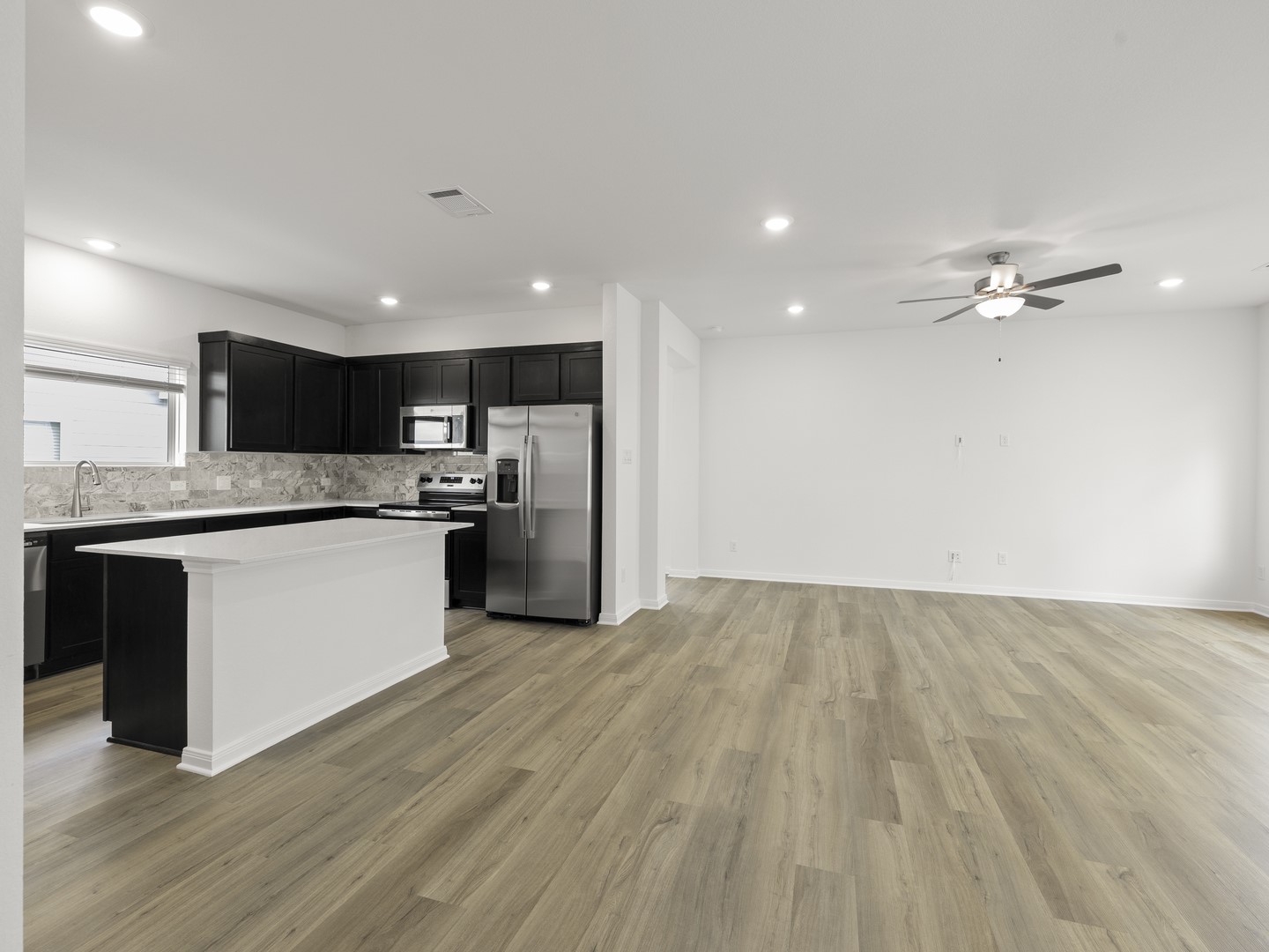 513 Yellow Ribbon Trail Jarrell, TX 76537 - Photo 7 of 23 An open concept design seamlessly connects the sleek kitchen to a spacious living area.