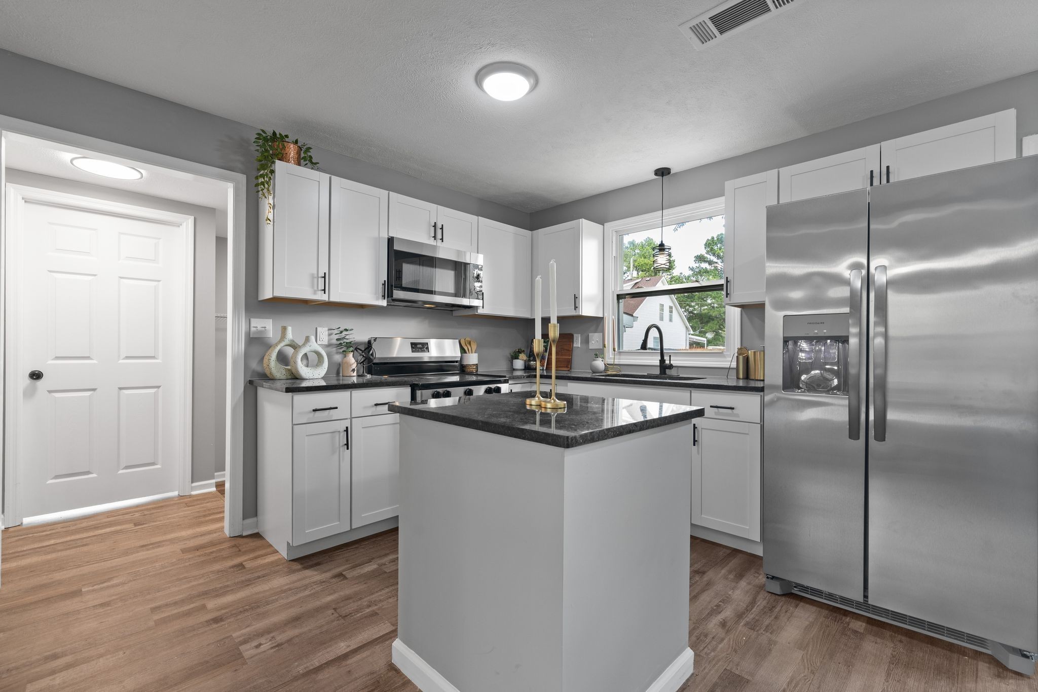 544 Stones River Road La Vergne, TN 37086 - Photo 10 of 26 a kitchen with kitchen island granite countertop a refrigerator a sink a stove a microwave and cabinets