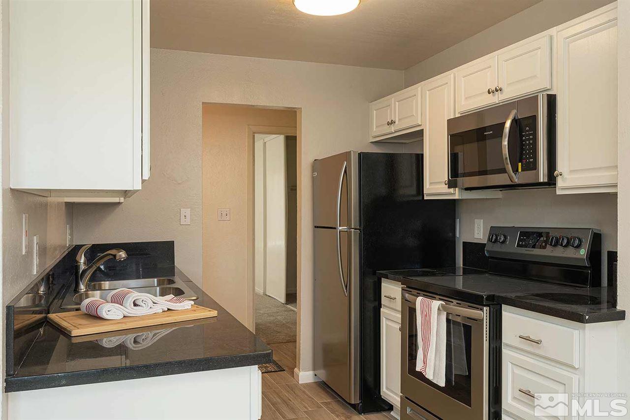 a kitchen with stainless steel appliances granite countertop a stove a refrigerator and a microwave