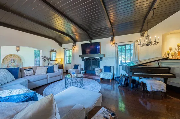 a view of a dining room with furniture a chandelier and wooden floor