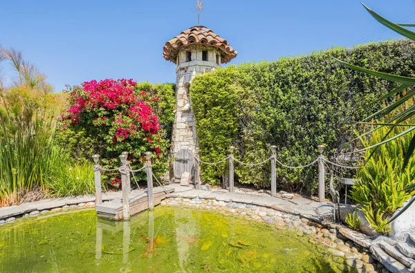 a front view of a house with a yard and a fountain