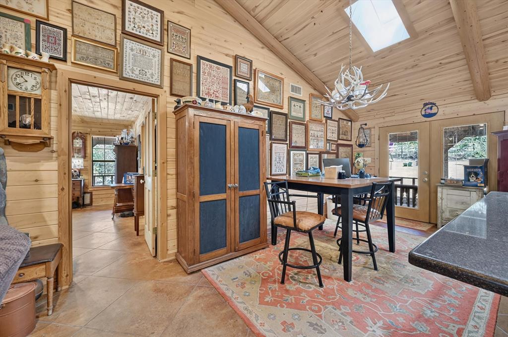 1623 3 Skillet Road Springtown, TX 76082 - Photo 8 of 40 Vaulted wood-paneled ceiling with a skylight, wood-planked walls, and tile flooring