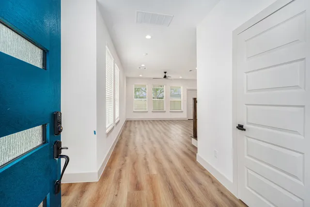 a view of a hallway with wooden floor and staircase