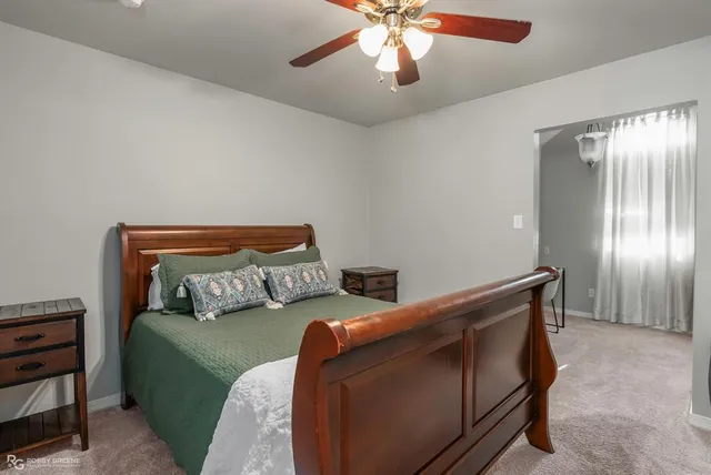 a bedroom with furniture and a chandelier fan