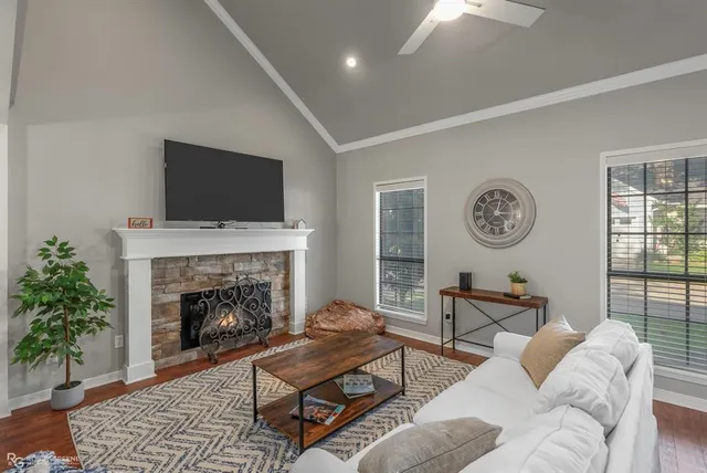 a living room with furniture a flat screen tv and a fireplace