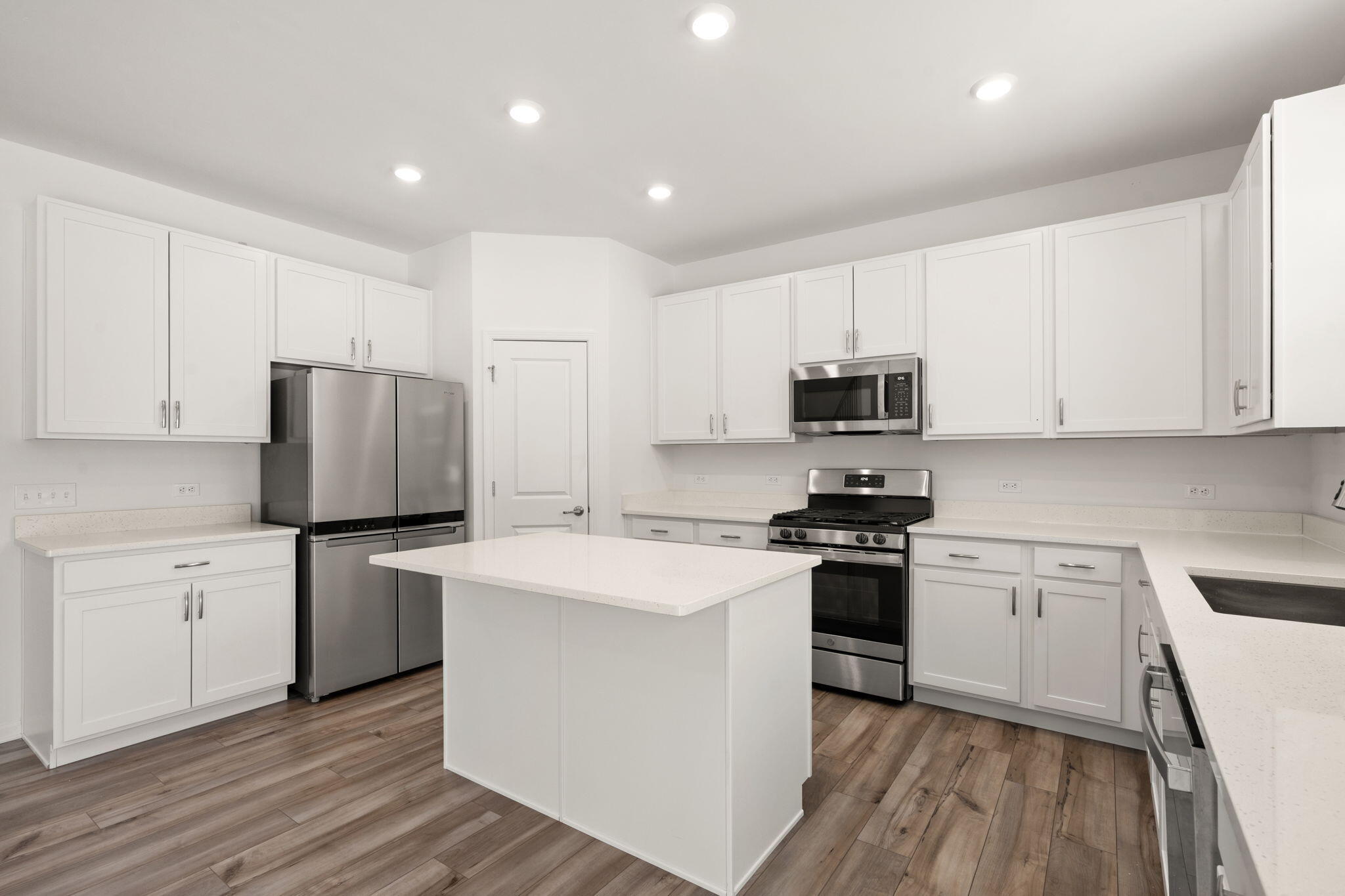 1811 East 111th Place Crown Point, IN 46307 - Photo 13 of 35 a kitchen with stainless steel appliances white cabinets and wooden floor