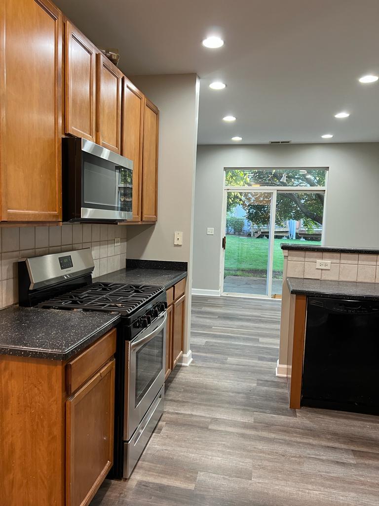 364 Risen Star Lane, Unit 364 Oswego, IL 60543 - Photo 2 of 15 a kitchen with stainless steel appliances granite countertop a stove a sink and a microwave