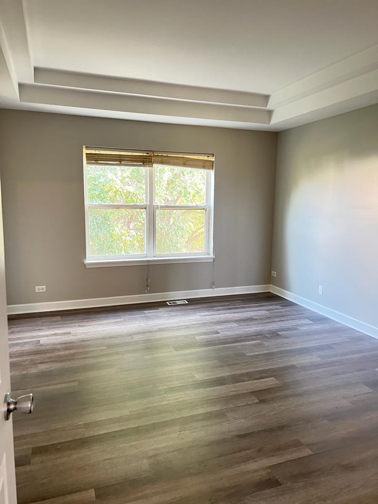 364 Risen Star Lane, Unit 364 Oswego, IL 60543 - Photo 5 of 15 a view of an empty room with wooden floor and a window