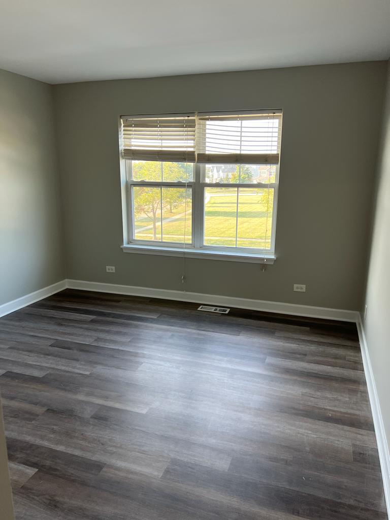 364 Risen Star Lane, Unit 364 Oswego, IL 60543 - Photo 9 of 15 a view of an empty room with wooden floor and a window