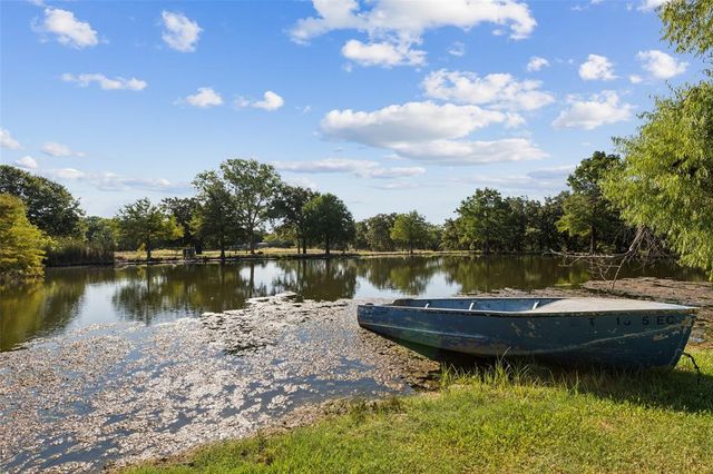 a view of a lake with a small yard and a wooden fence