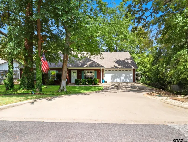 a front view of a house with a yard and tree s
