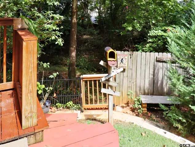 a view of a house with a small yard and wooden fence