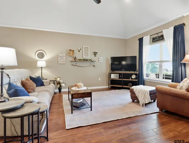 a living room with furniture a flat screen tv and a large window