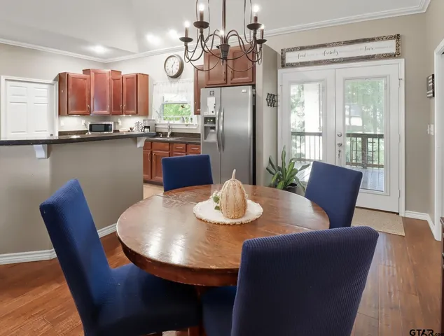 a view of a dining room with furniture a chandelier and wooden floor