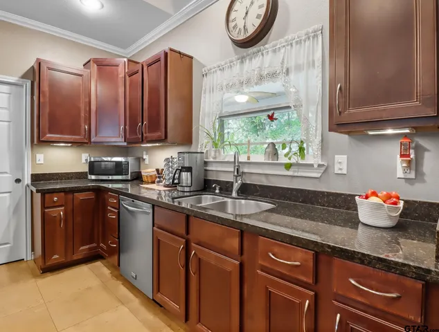 a kitchen with stainless steel appliances granite countertop a sink a stove and a wooden cabinets