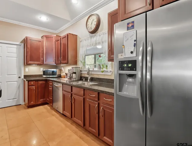 a kitchen with stainless steel appliances granite countertop a refrigerator a sink and dishwasher