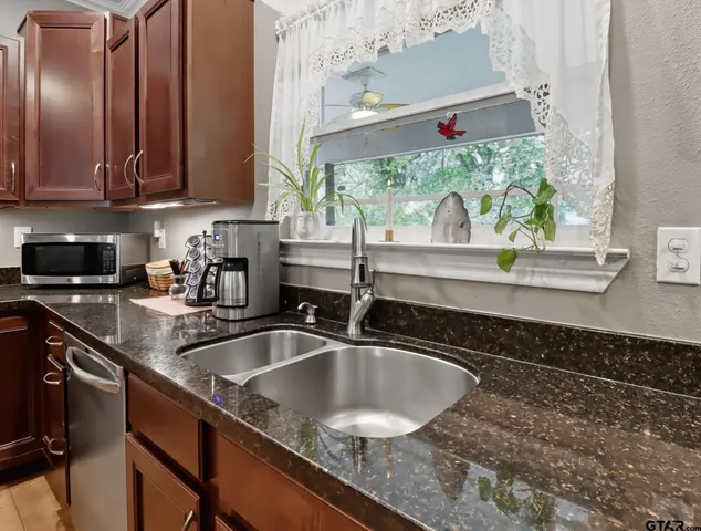 a kitchen with granite countertop a sink and a window