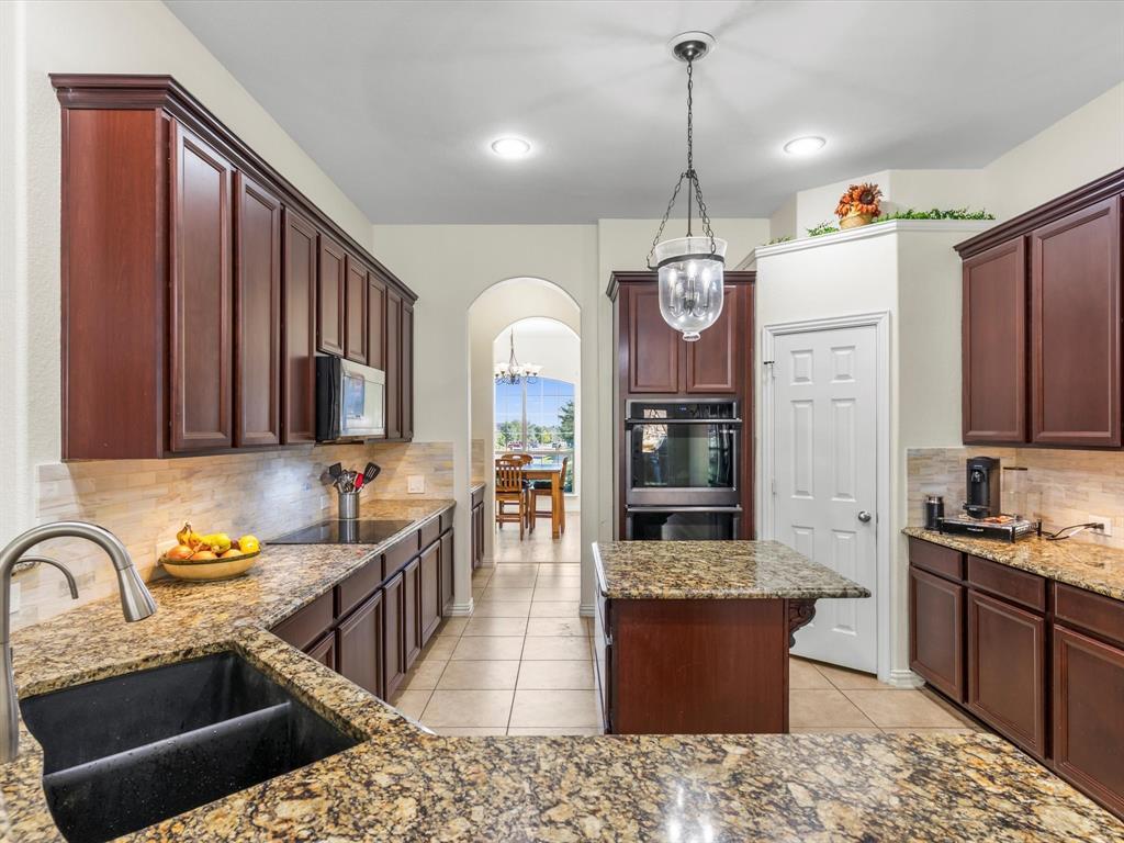 437 Hackworth Street Roanoke, TX 76262 - Photo 13 of 35 a kitchen with stainless steel appliances granite countertop a stove a sink dishwasher and a refrigerator with wooden floor