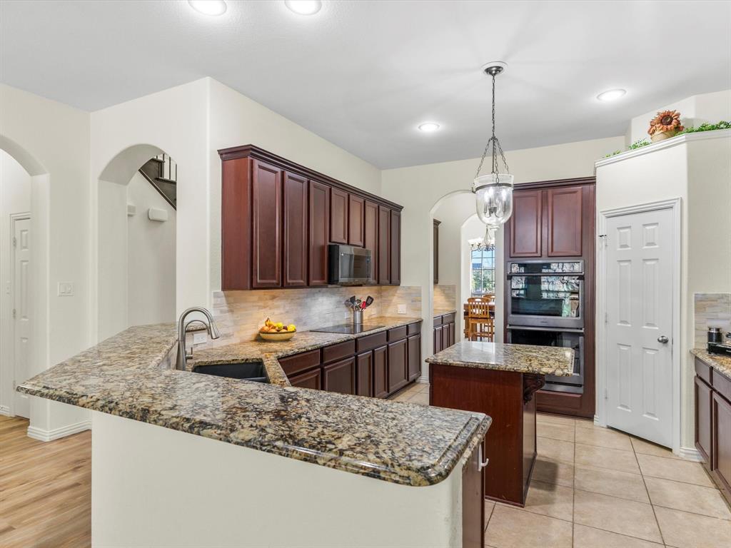 437 Hackworth Street Roanoke, TX 76262 - Photo 14 of 35 a kitchen with granite countertop a sink and a stove