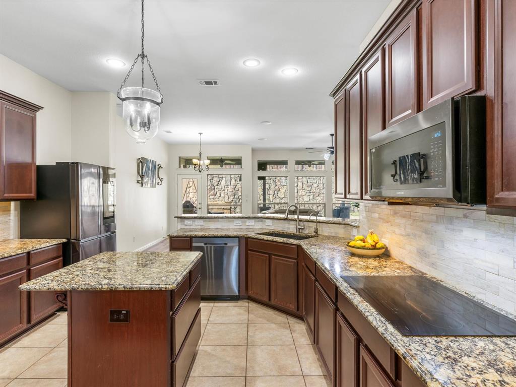 437 Hackworth Street Roanoke, TX 76262 - Photo 15 of 35 a kitchen with stainless steel appliances granite countertop a sink stove and refrigerator