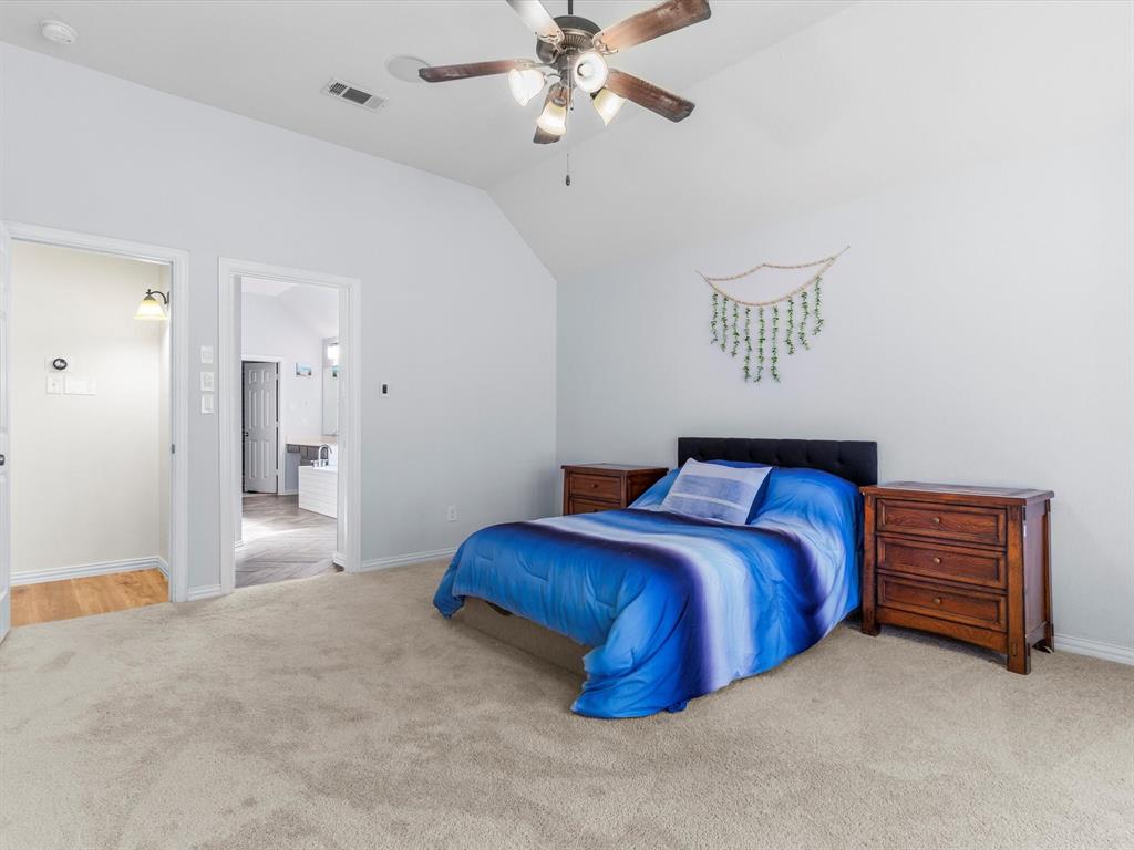 437 Hackworth Street Roanoke, TX 76262 - Photo 17 of 35 a bedroom with a bed and a chandelier