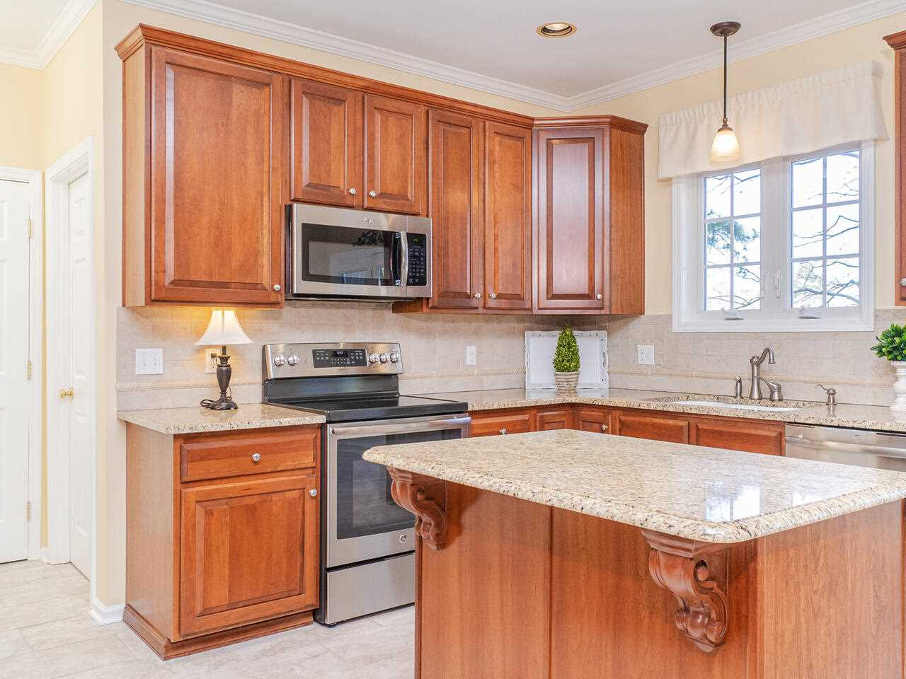 426 Seastone Street Raleigh, NC 27603 - Photo 16 of 30 a kitchen with stainless steel appliances granite countertop wooden cabinets a sink and dishwasher a stove with wooden floor