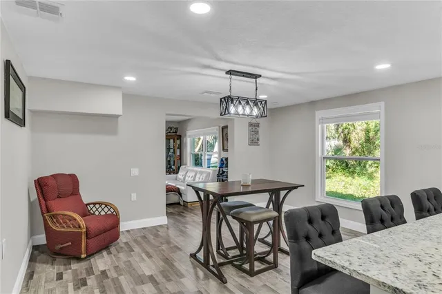 a view of a dining room with furniture a chandelier and wooden floor