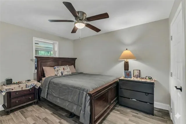 a bedroom with a bed and a lamp on dresser