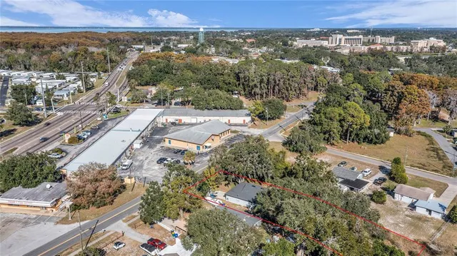an aerial view of residential houses with outdoor space and trees