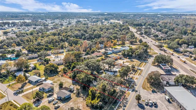 an aerial view of residential house with outdoor space and trees all around