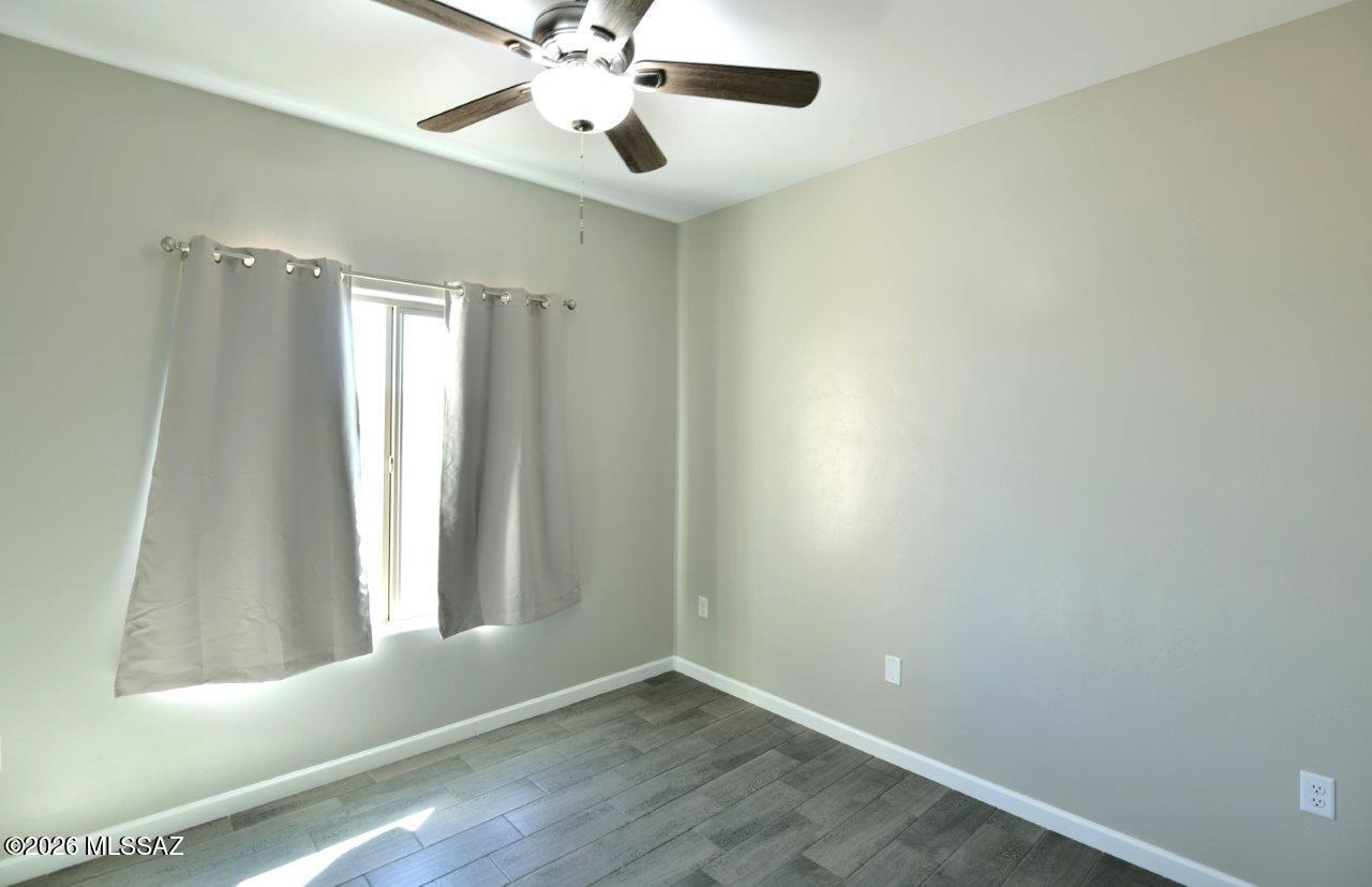 1091 North Vail View Road Vail, AZ 85641 - Photo 28 of 43 an empty room with wooden floor fan and windows