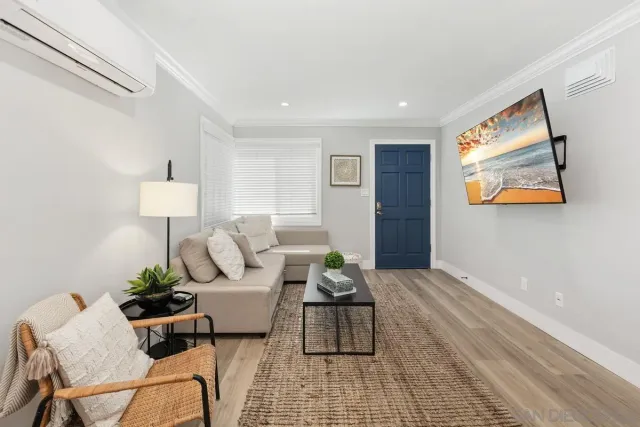 a living room with furniture and a lamp on table with wooden floor
