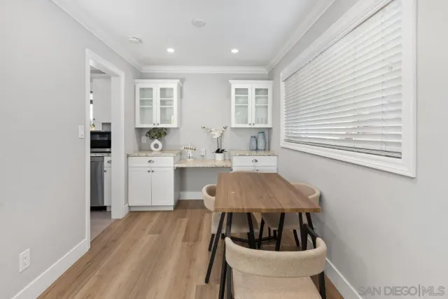 a kitchen with white cabinets a sink a stove and a window