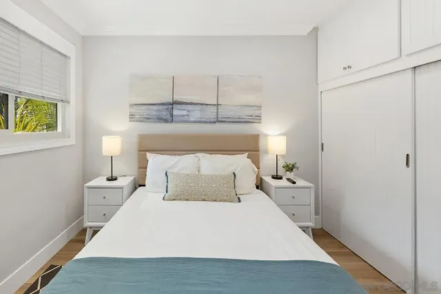 a bedroom with a bed and painting on the wall