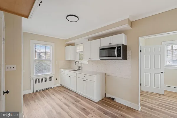 a view of a kitchen with wooden floor and windows