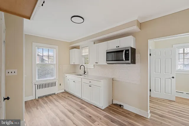 a view of a kitchen with wooden floor and windows