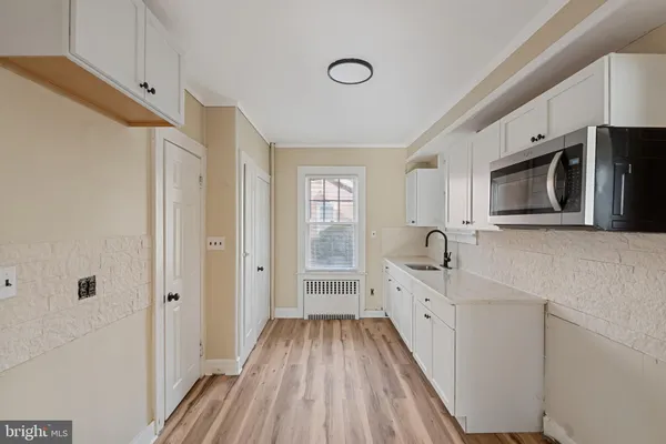 a large white kitchen with stainless steel appliances