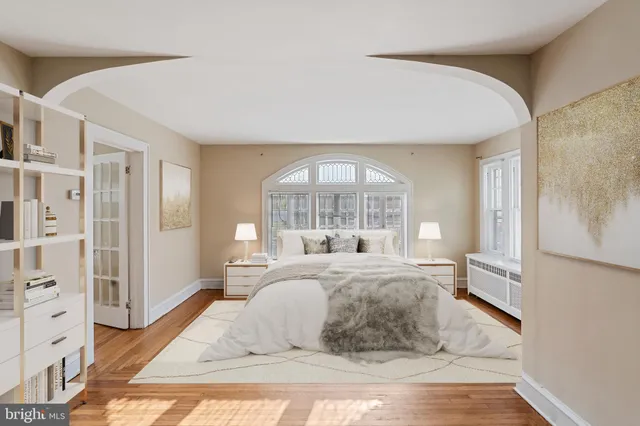 a bedroom with a large bed and a wooden floor