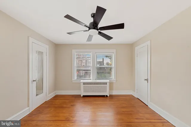 a view of room with wooden floor and a ceiling fan