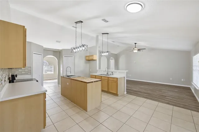 a large kitchen with kitchen island a sink stainless steel appliances and cabinets