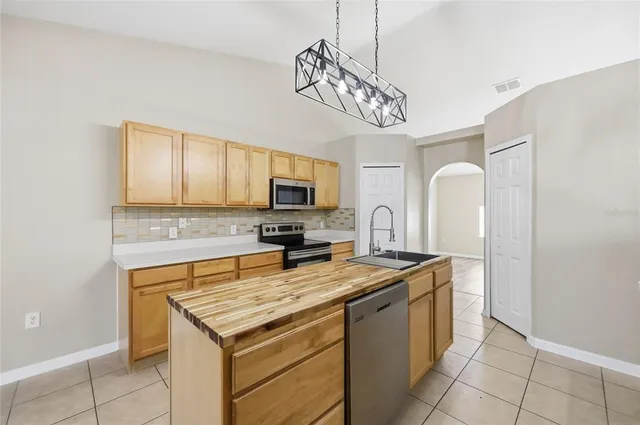 a kitchen with stainless steel appliances granite countertop a stove refrigerator a sink dishwasher and microwave with wooden floor