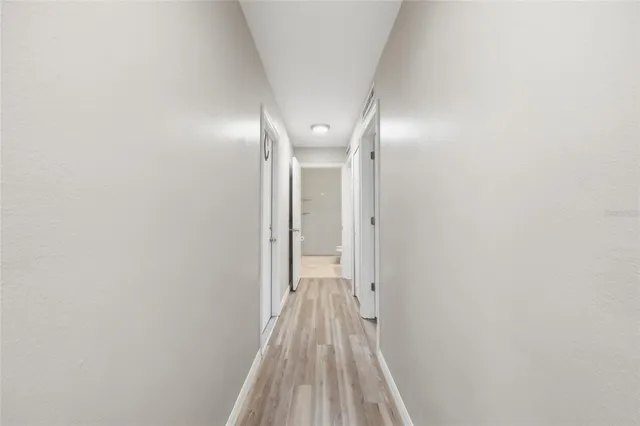 a view of a hallway with wooden floor